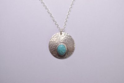 NP42. Hammered silver circle pendant with oval turquoise stone
