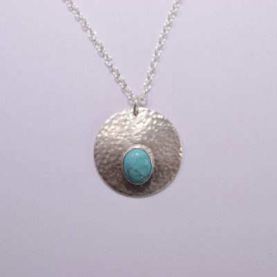 NP42. Hammered silver circle pendant with oval turquoise stone