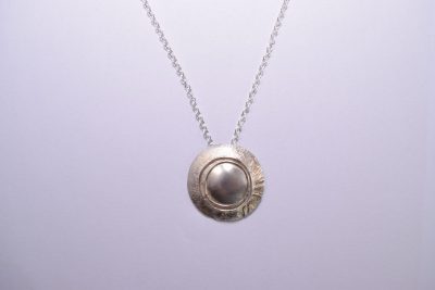 NP43. Layered silver disks with silver wire detail pendant