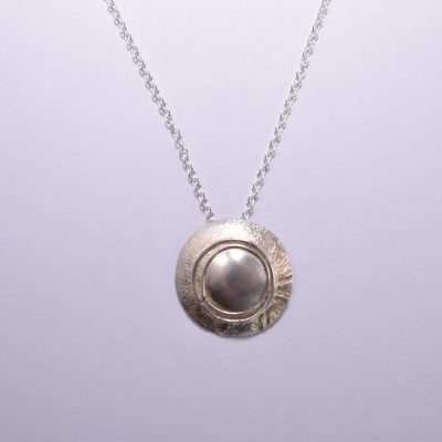 NP43. Layered silver disks with silver wire detail pendant