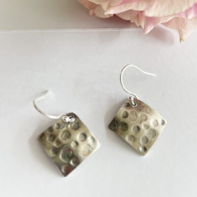 EA84. Diamond shape pitted earrings with oxidation